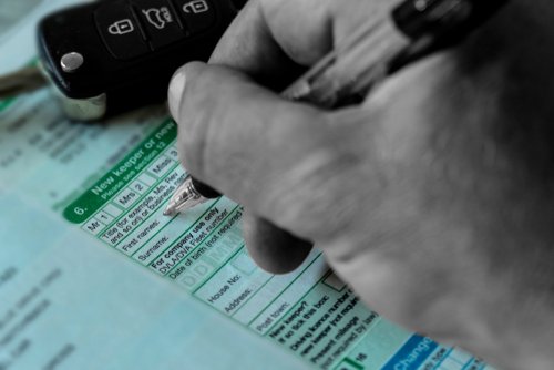 Man filling in V5 document after selling his scooter