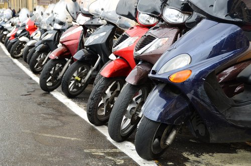 Scooters and motorcycles lined up in a row