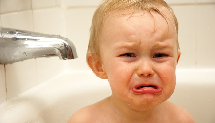 Sad baby in a bath tub